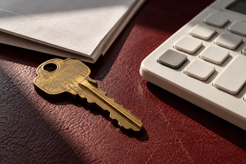 A house key beside a calculator
