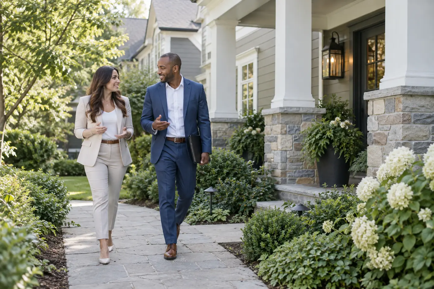 Two real estate professionals walking toward a home
